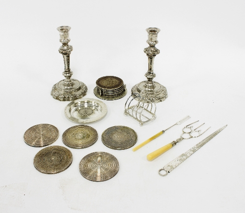 A pair of white metal candlesticks,