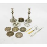 A pair of white metal candlesticks,