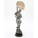 An Art Nouveau figural table lamp modelled in spelter as a maiden holding a lily,