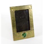 An Arts and Crafts brass mounted photograph frame set with Ruskin style green glazed rondel to base,