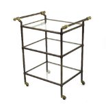 A brass and metal framed buffet trolley, fitted glass shelves on brass castors,