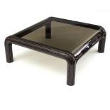 A 20th Century Parker Knoll coffee table, the square smoky glass top to stylised metal supports,