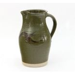 Russell Collins, Hook Norton Pottery/A green baluster jug with brush decoration to the body,