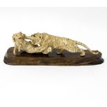 A Japanese carved ivory figure group, Meiji period, depicting a tiger attacking a goat and its kid,