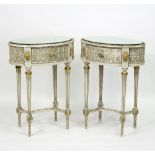 A pair of painted oval bedside tables, each with mirrored top above a single drawer,