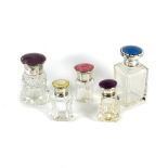 Five enamel and silver mounted scent bottles, each with coloured guilloche enamel cover,