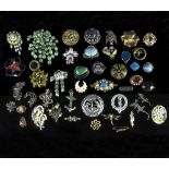 A large collection of various silver and gem set brooches,