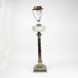 A silver plated oil lamp, the Corinthian column support with clear cut glass well,