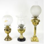 A Victorian brass oil lamp with Corinthian column and clear glass fluted shade and two others