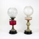 A Victorian brass mounted oil lamp with cranberry glass and floral frosted shade,