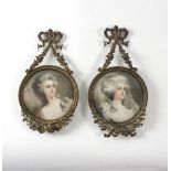 A pair of early 20th Century gilt metal miniature frames with ribbon tie surmounts,