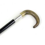 An ebonised walking cane with horn handle and silver collar