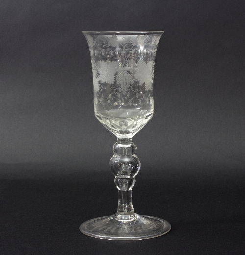 A glass goblet, circa 1760, engraved with vines on a hollow baluster stem and folded foot, 21.
