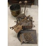 A brass coal bucket with embossed armorial and lion mask ring handles and a group of fire irons