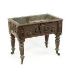 A Victorian carved oak wine cooler, the screw-on legs with brass caps and castors, 79.