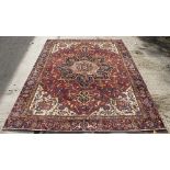 A carpet of Eastern design with allover red ground geometric field,