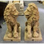 A large pair of terracotta lions, each modelled seated on a plinth resting a paw on a ball,