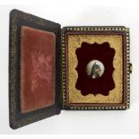 An enamelled plaque depicting an American terrier, in a velvet backed frame and papier-mâché case,