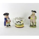 A Staffordshire Toby jug modelled as a standing toper by a naturalistic stump,