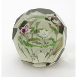 A 19th Century faceted glass paperweight, with four lampwork flowerheads surrounding an oval plaque,