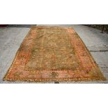 A Turkey carpet with allover stylised floral design on an orange ground,