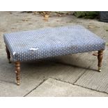 An upholstered stool, on turned legs with castors,