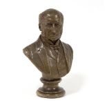 A plaster bust of a Victorian gentleman wearing a tie, waistcoat and jacket, on a circular socle,