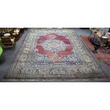 A large Indian carpet with central blue ground, geometric medallions and multi figured border,