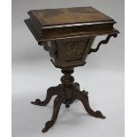 A Victorian walnut work table with hinged cover, turned column support on carved scrolling legs,