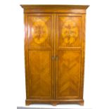 An Edwardian satinwood wardrobe, the pair of doors ebony strung and inlaid ovals, on bracket feet,