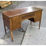 An Edwardian mahogany dresser fitted a single drawer above a kneehole flanked by two cupboards,