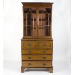 A Regency mahogany secretaire bookcase the top enclosed by glazed, shaped bar doors,