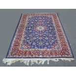 A Tabriz carpet with floral blue ground central field within a red ground border,