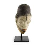 A Punu mask, Gabon, with white face and pierced eye slits,