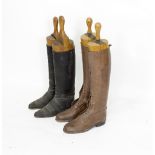 Two pairs of leather riding boots with wooden trees, one black pair,