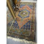 An Eastern rug with central medallion to a brick red ground, within a multiple border,