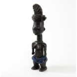A carved Attie figure, Ivory Coast, depicting a standing figure in headdress,