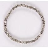 A diamond tennis bracelet of thirty-six brilliant cut diamonds set to a white metal mount,