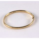 A 9ct gold hinged bangle, of plain form, approximately 23.