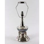 A white metal table lamp, of baluster form with figural supports,