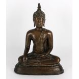 A South East Asian bronze figure of the seated Buddha, calling the earth to witness,