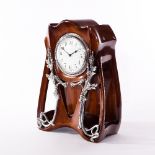 An Art Nouveau mantel clock with a moulded mahogany case applied silvered metal mounts,