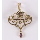 An Edwardian amethyst and seed pearl pendant/brooch to a scroll openwork 9ct setting