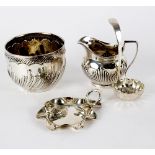 A Victorian silver sugar bowl, London 1883, a similar jug, a small tray and a sifter spoon,