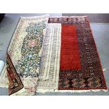 Three Eastern rugs, the largest with a plain rust red field within a multifield border,