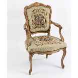 A beech framed fauteuil with floral needlework back,