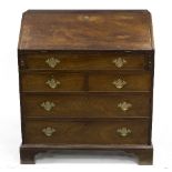 A George III mahogany bureau with fitted interior above an arrangement of two short and three long