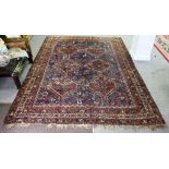 A Hamadan rug with twin triple pole medallions on a red ground,