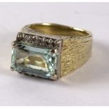 A diamond and blue topaz dress ring, the rectangular step cut topaz approximately 6mm wide,