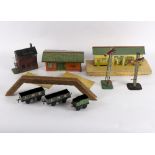 A Hornby tin plate station, a Hornby series shed, two signals and three trucks,